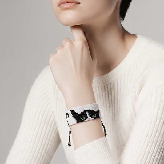 Model wearing Feline Muse Miyuki beaded cat cuff bracelet styled with a white knit sweater