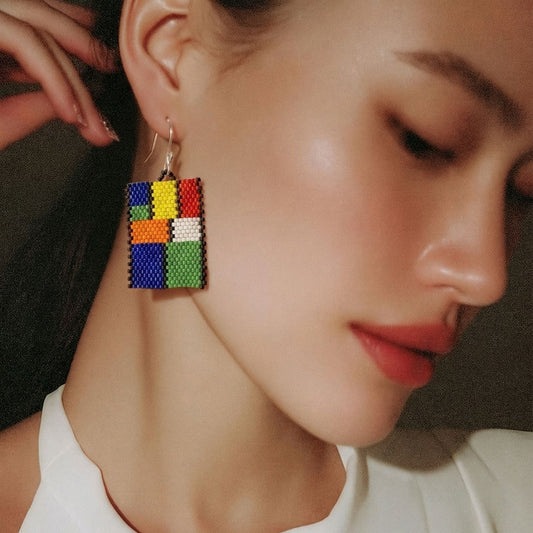 Model wearing colorful Mondrian-inspired Miyuki Delica peyote earrings by Dailot