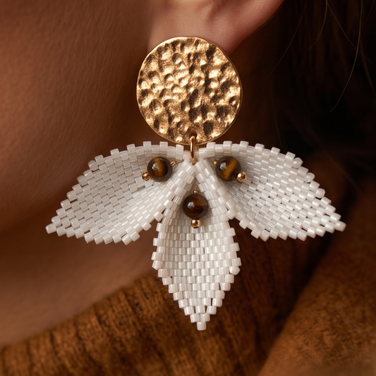 Close-up of Petal Sculpture earrings worn by a model, highlighting ivory Miyuki beadwork, dimensional petals and hammered gold-tone studs.