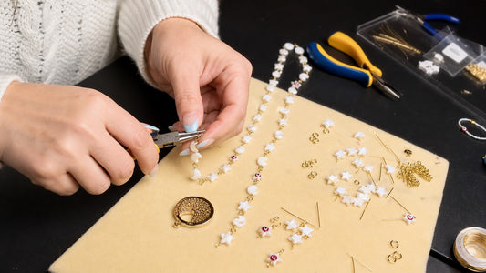 Dailot artisan assembling handmade jewelry with pliers in a small studio