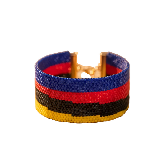 Dailot wide beaded bracelet with blue, red, black, and yellow horizontal stripes and gold-tone accents on a white background.