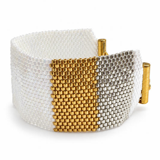 Dailot wide bracelet with pearlescent white beads and gold-tone and silver-tone panels, centered on a white background.