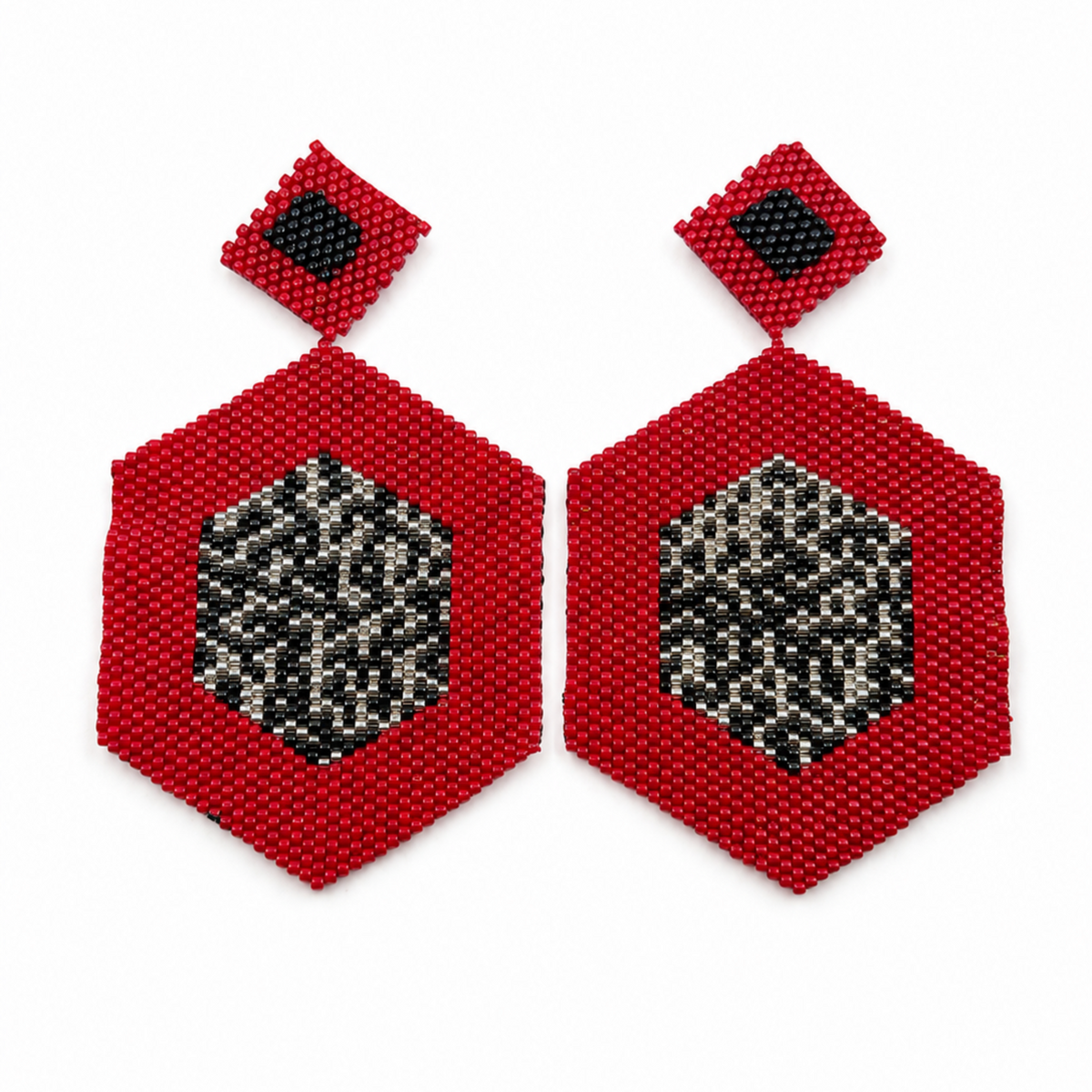 Red geometric beaded drop earrings with black and silver-tone patterned centers on a white background.